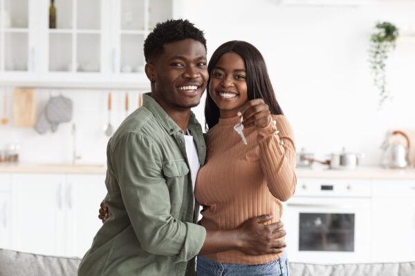 happy couple holding keys to their new house smiling excited